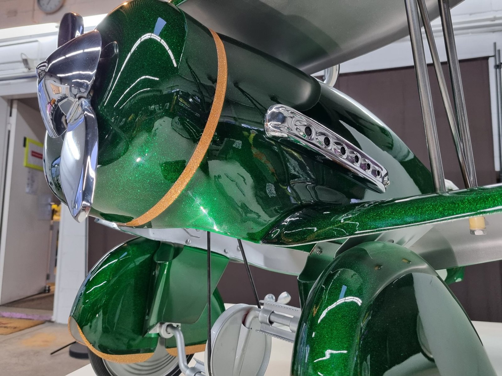 Ein grünes Flugzeug steht auf einem Tisch in einer Garage